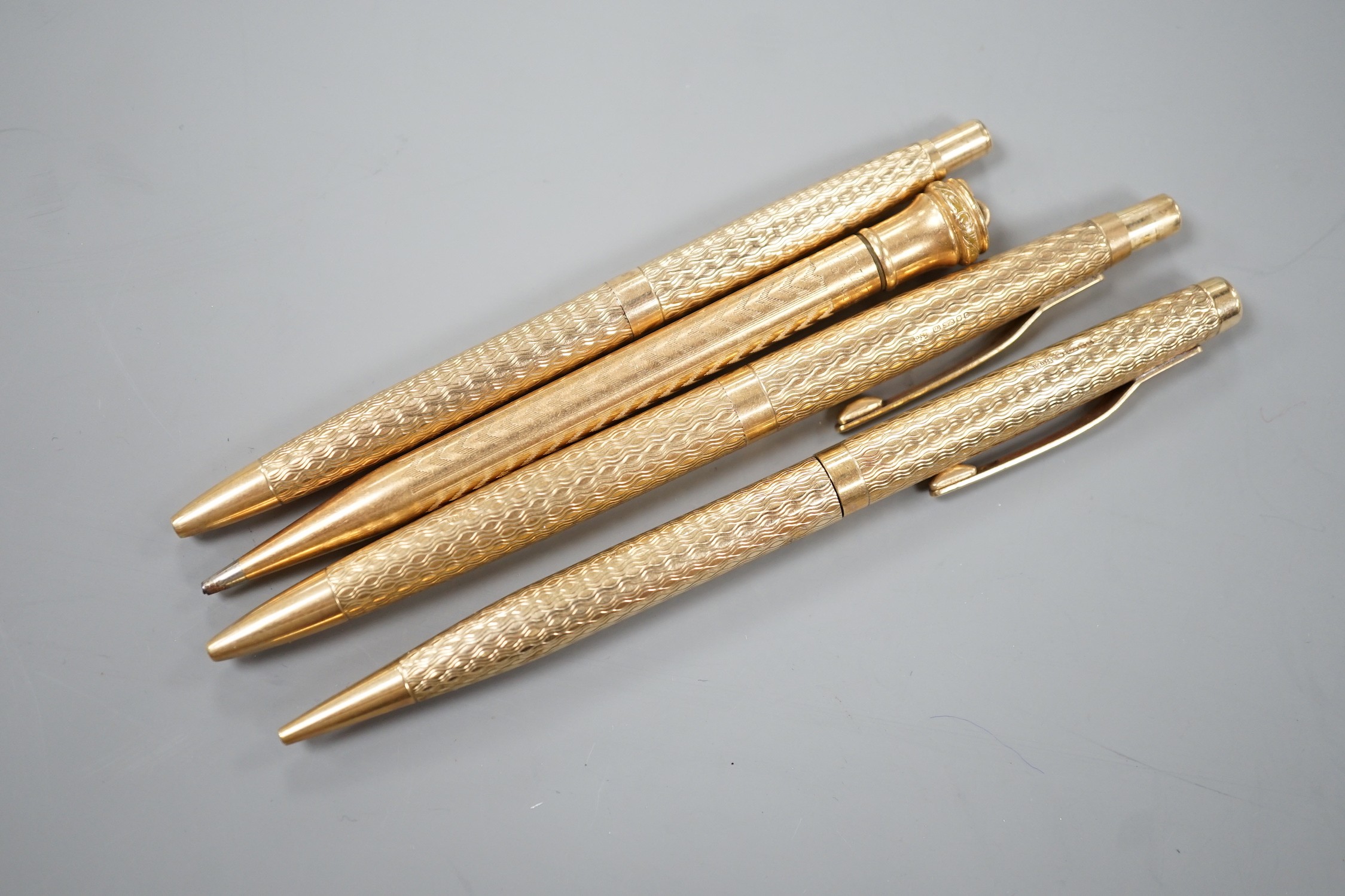 Three 9ct gold case ballpoint pens and a gold filled pen.